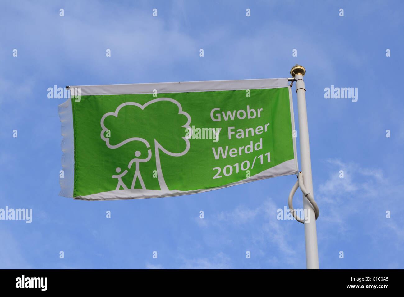 Green Flag Award in Welsh, against a blue sky, at Gnoll Country Park, Neath, South Wales Stock Photo