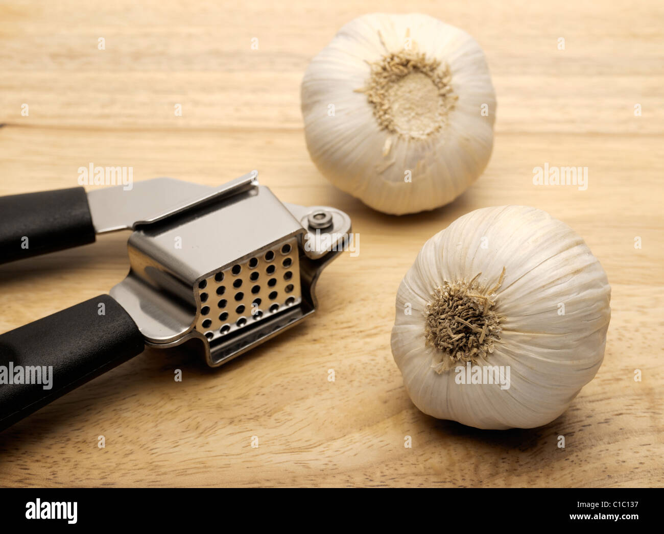 Garlic press and two cloves of garlic Stock Photo Alamy