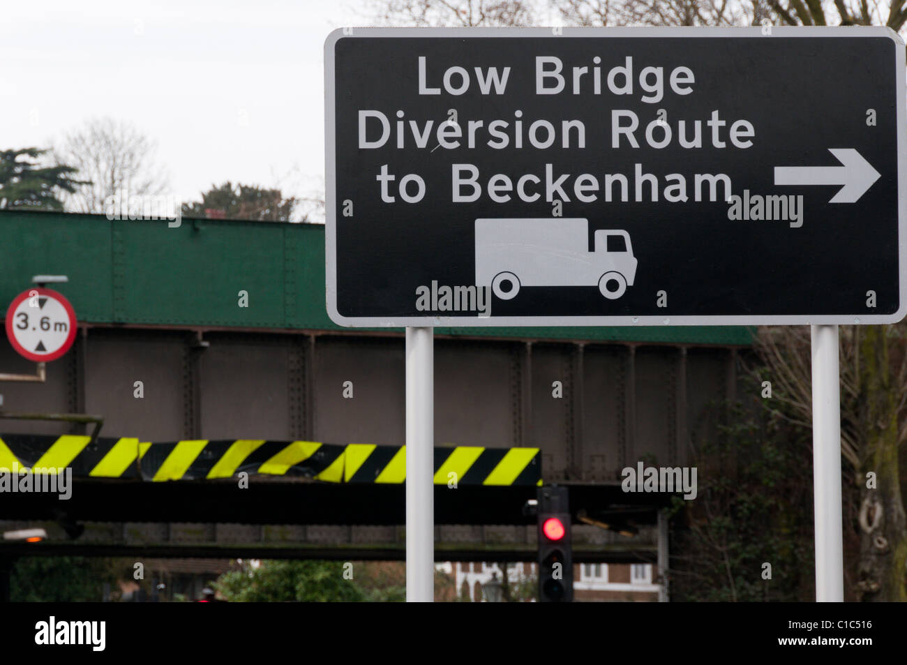 A road sign for a diversion route to Beckenham avoiding the low bridge outside Shortlands railway station (in background). Stock Photo