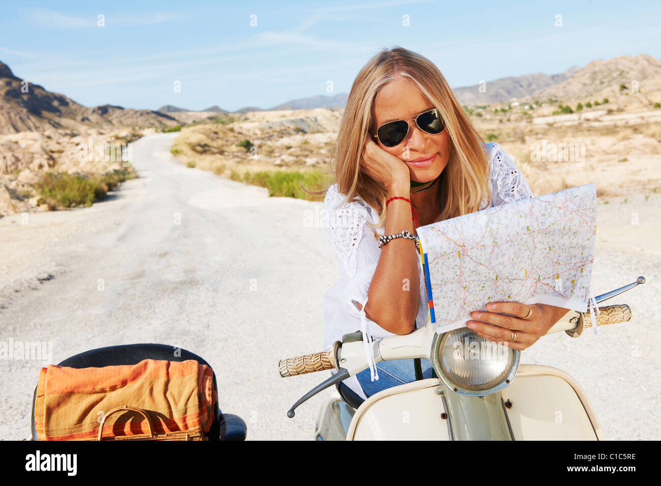 Woman Sitting on motorbike with map Stock Photo