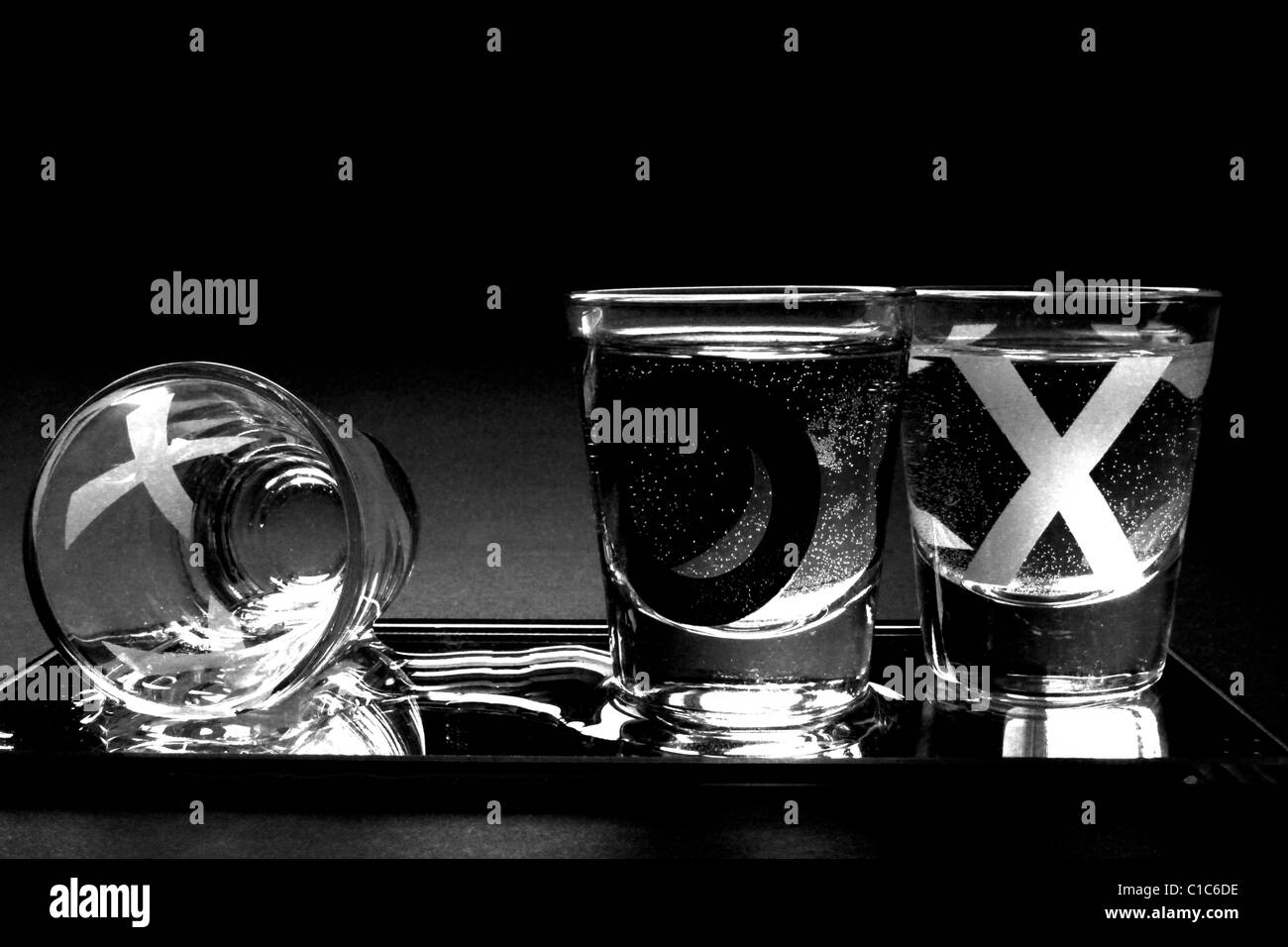 Noughts and Crosses Shot Glasses on Black Background shot from eye level Stock Photo