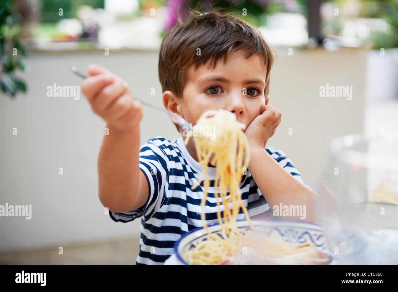 Young boy eating spaghetti Stock Photo