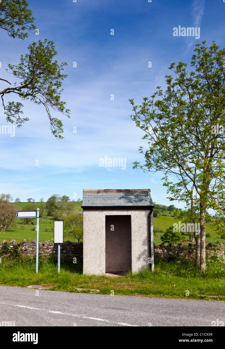 Small rural countryside bus stop and shelter with blank signs, England UK Stock Photo