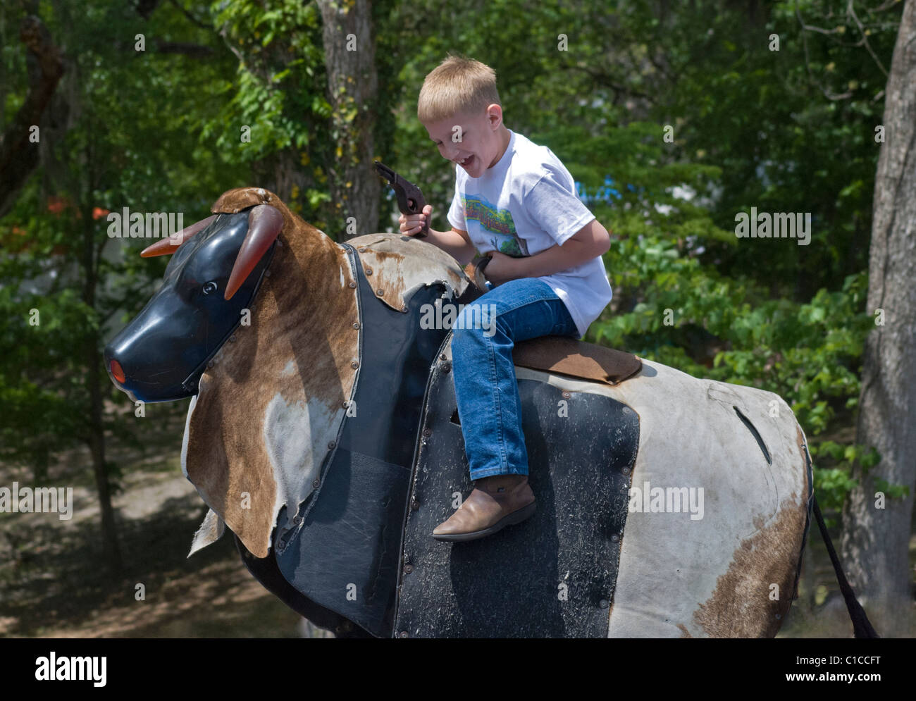 Pioneer Days festival in High Springs Florida boy riding mechanical bull and pretending he's a cowboy Stock Photo