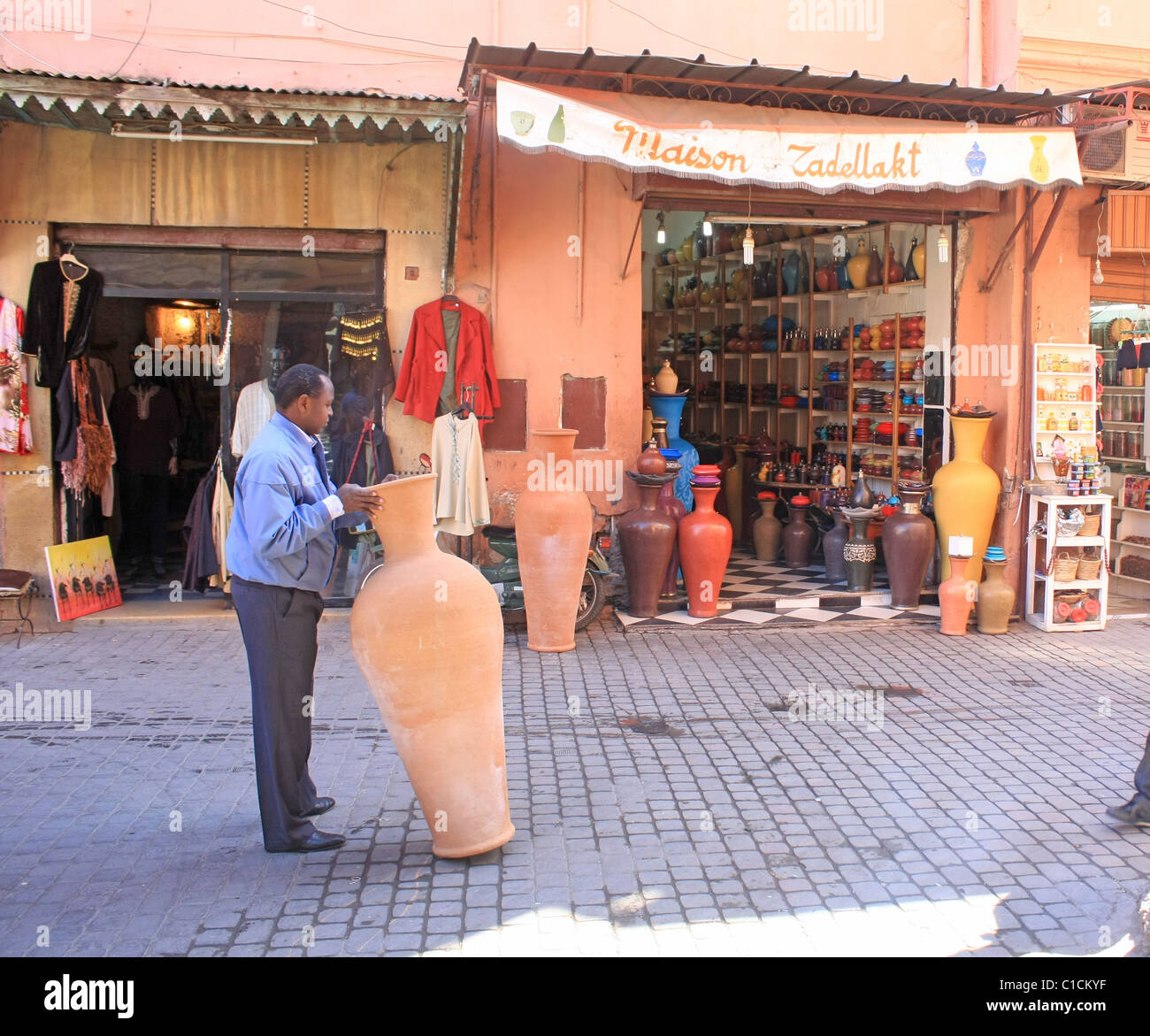 A man delivers a pot to a shop in the souks in Marrakech Stock Photo