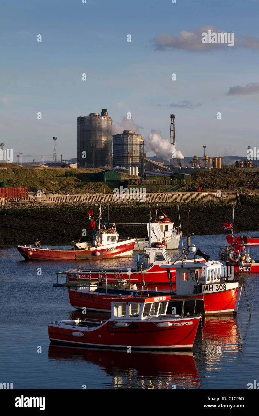 Fishermen's Boats at anchor in Paddy's Hole harbour, mini-harbour Inlet and the British steel Steelworks at South Gare, Redcar, North Yorkshire, UK Stock Photo