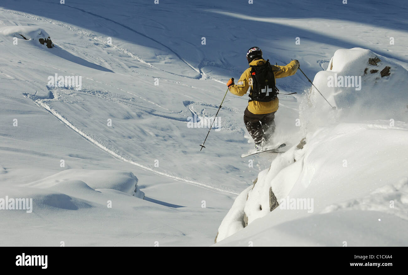 A skier jumps off rocks whilst skiing off piste in the ski resort of ...
