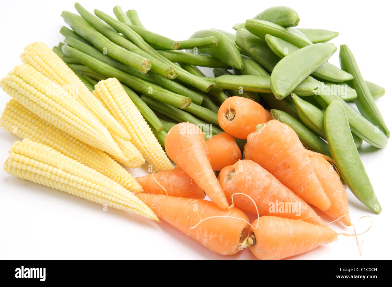 Fresh Baby Carrots, Baby Corn, Long Green Beans and Sugar Snaps, isolated on a white background table, lit with a large light so Stock Photo