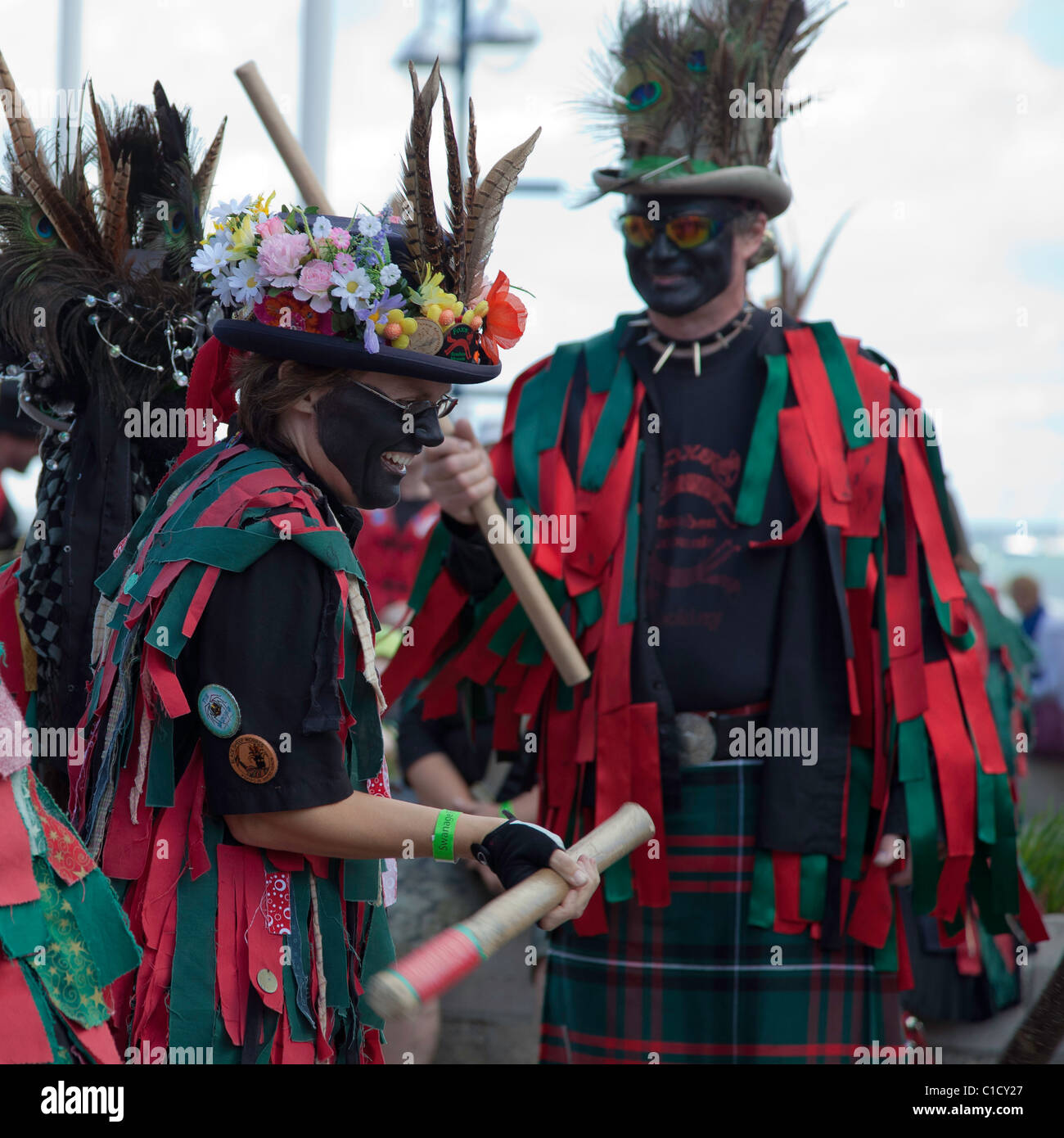Traditional English Morris Dancing Men & Women In Rag Jackets & Blacked Faces with Sticks at Swanage end of season Folk Festival Stock Photo