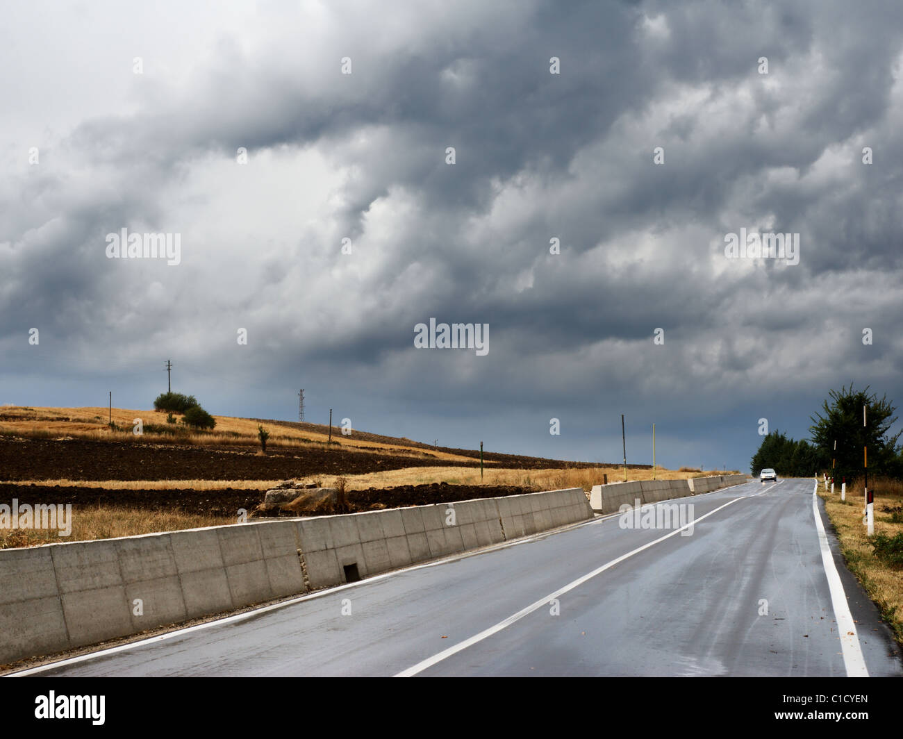 Traveling along country road in dark stormy weather Stock Photo