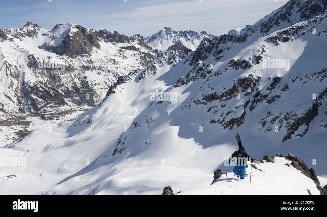 A free skier hiking up a snowy mountain ridge near La Grave, France. Stock Photo