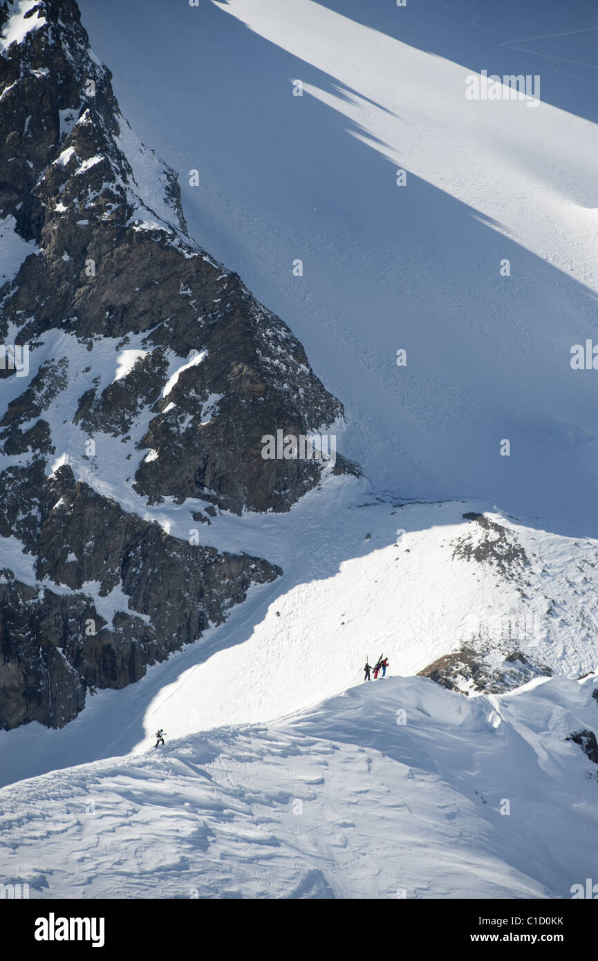 A group of free skiers climbing up a snowy mountain ridge at Serre Chevalier,  France Stock Photo