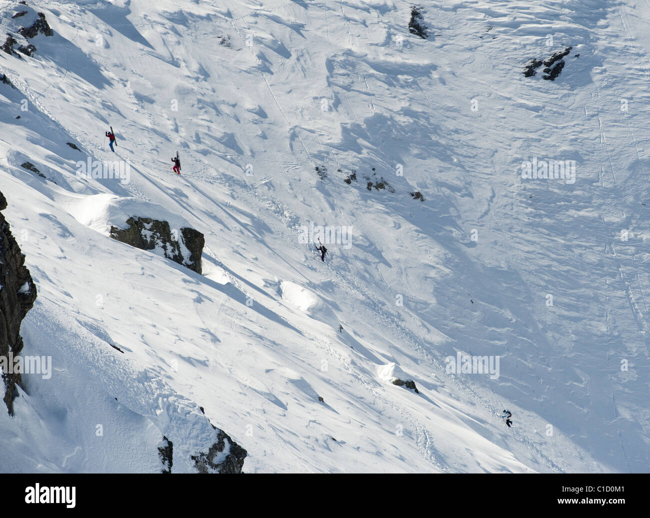 A group of free skiers climbing up a snowy mountain wall at Serre Chevalier,  France Stock Photo