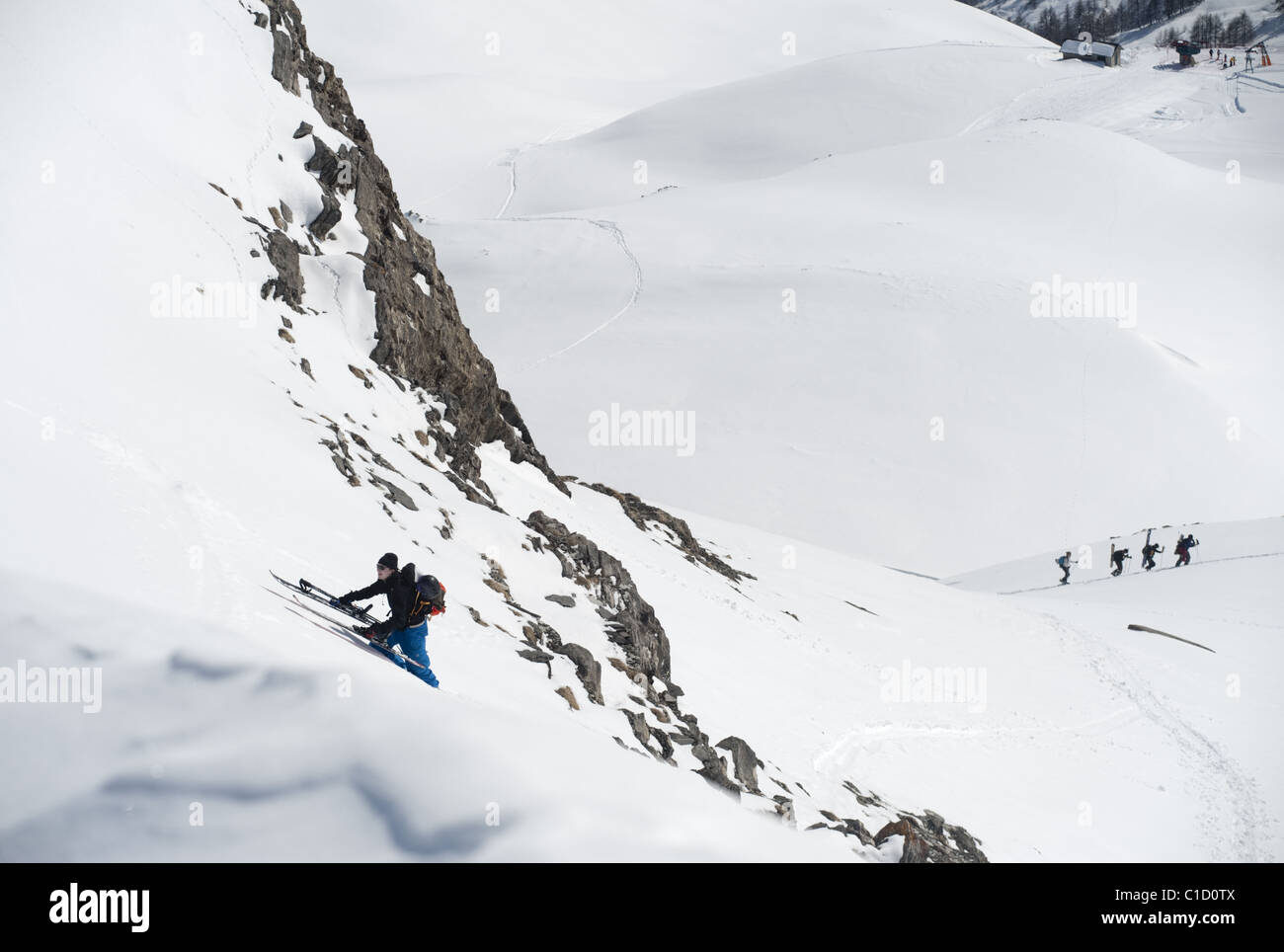 A free skier climbing up a snowy mountain side in Argentera, Italy Stock Photo