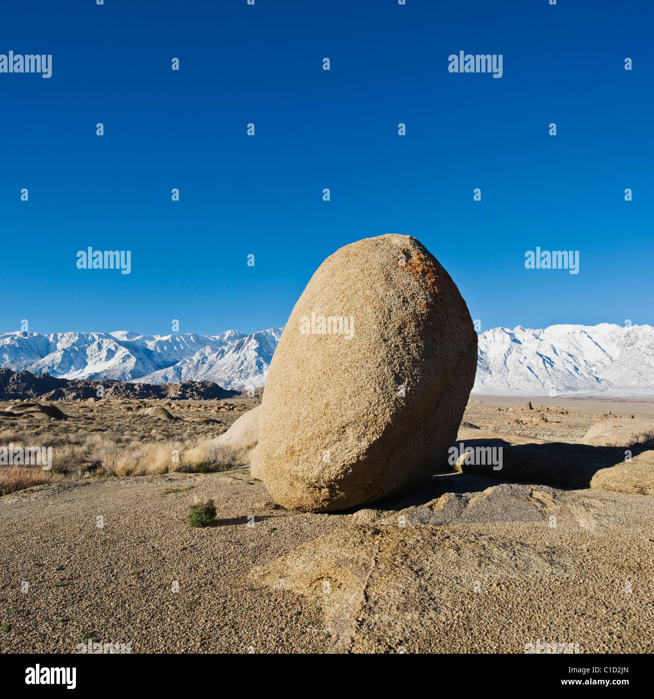 Single granite boulder of Alabama Hills and Sierra Nevada mountains in distance, Owen's Valley, California Stock Photo