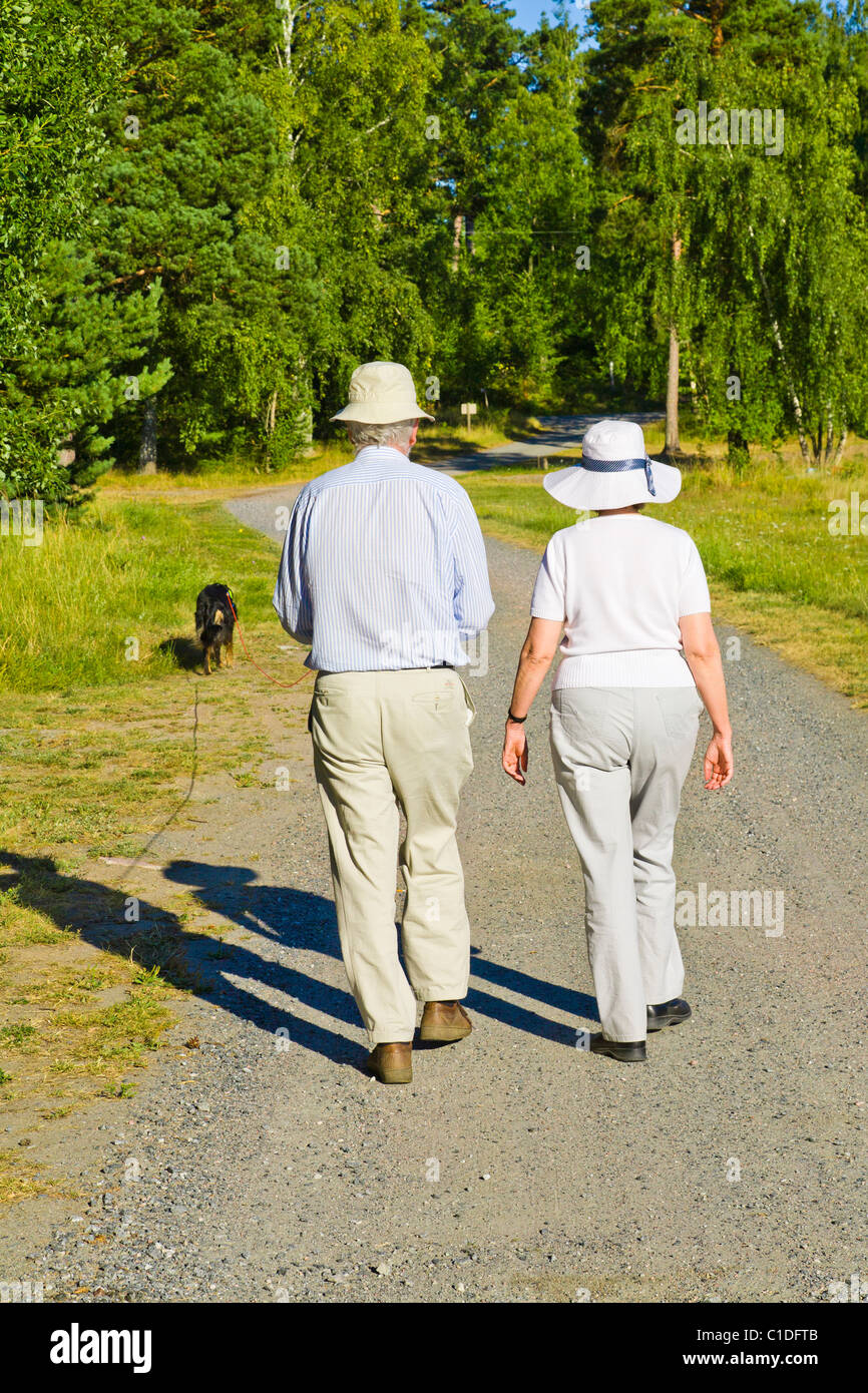 Senior couple walking a dog Stock Photo - Alamy
