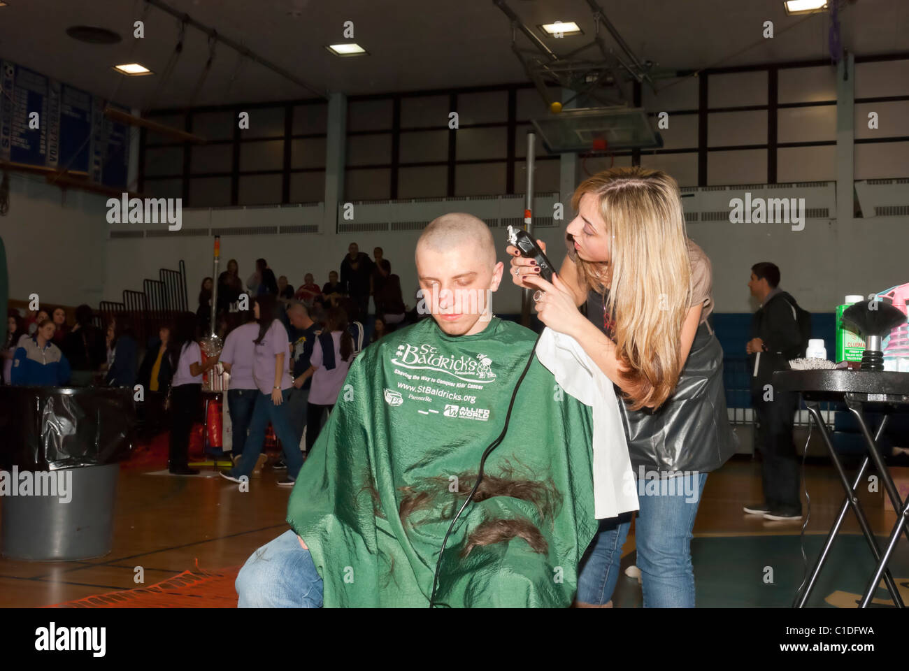 MARCH 15, 2011 - MERRICK NY: St. Baldrick's Day charity event at Calhoun High School, bald teen boy student having head shaved Stock Photo