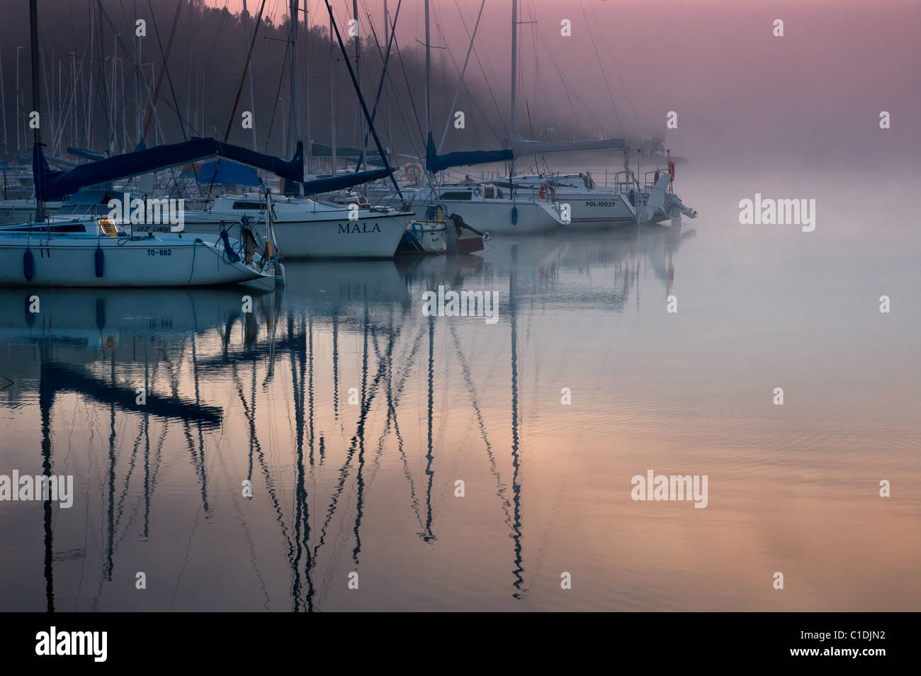 Colorful view of a yachts moored at Nidzkie Lake, Poland. Cold and foggy morning Stock Photo