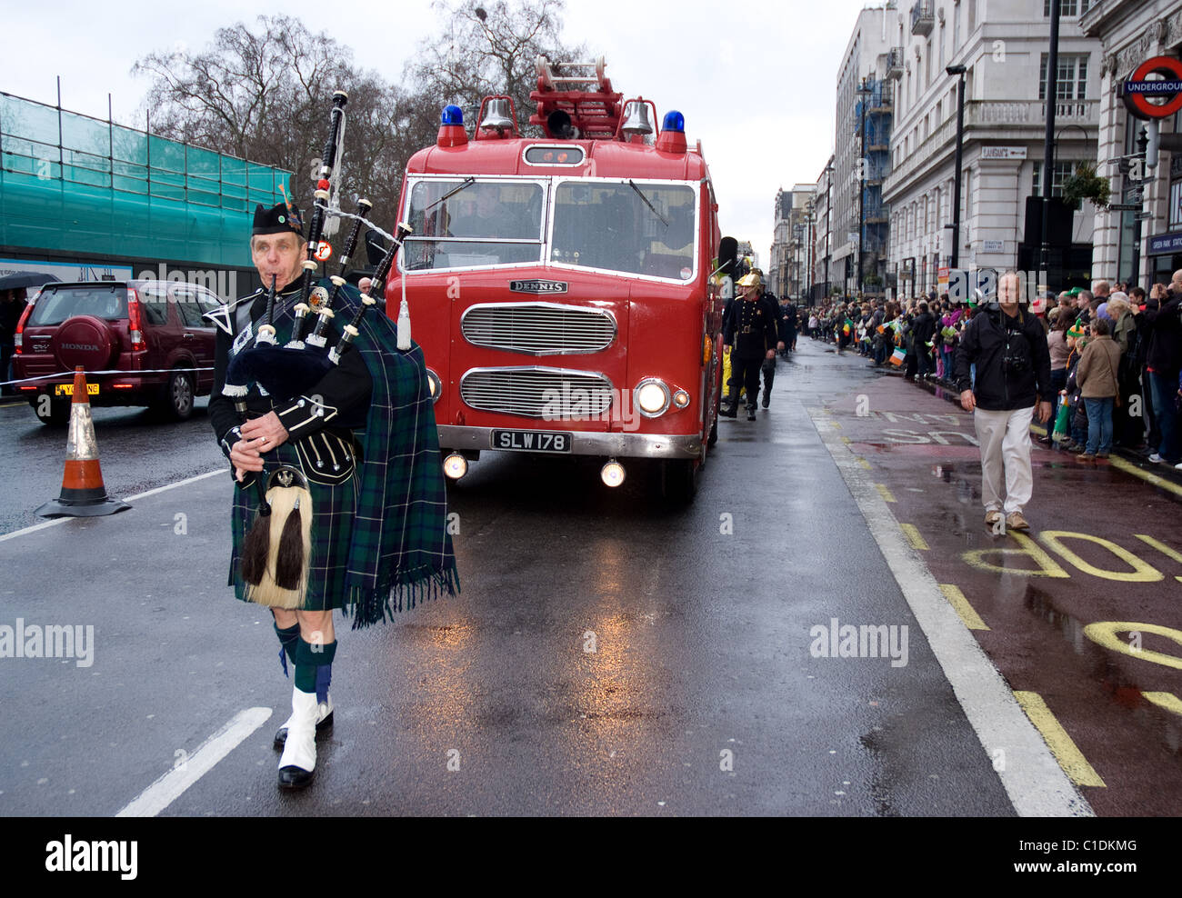 A lone bagpipe player leads the London Fire Brigade, during  the St Patrick`s day Parade, London 2011 Stock Photo