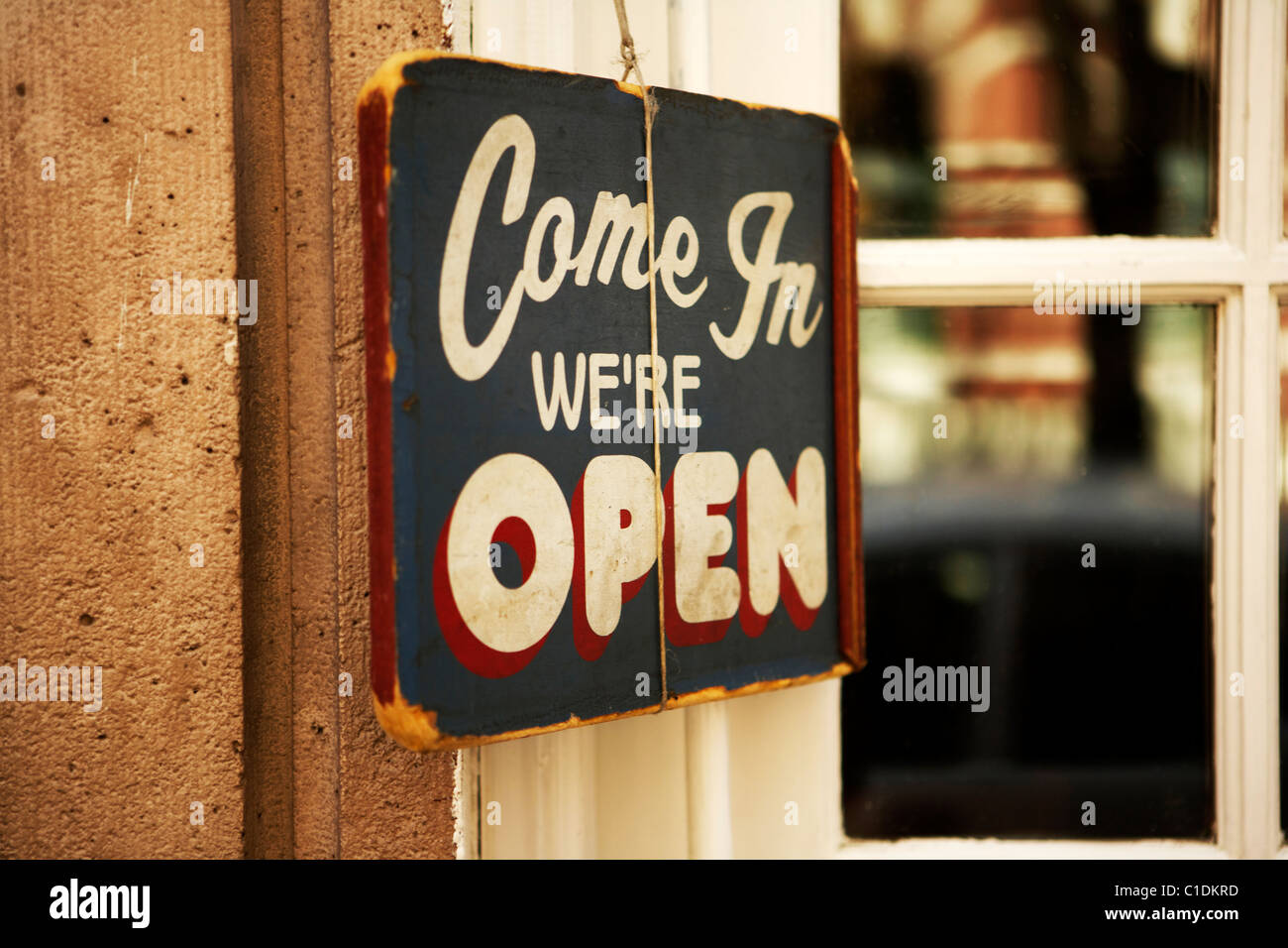 Come in we're open sign hanging on a wall outside a restaurant in the West Village in New York city USA Stock Photo