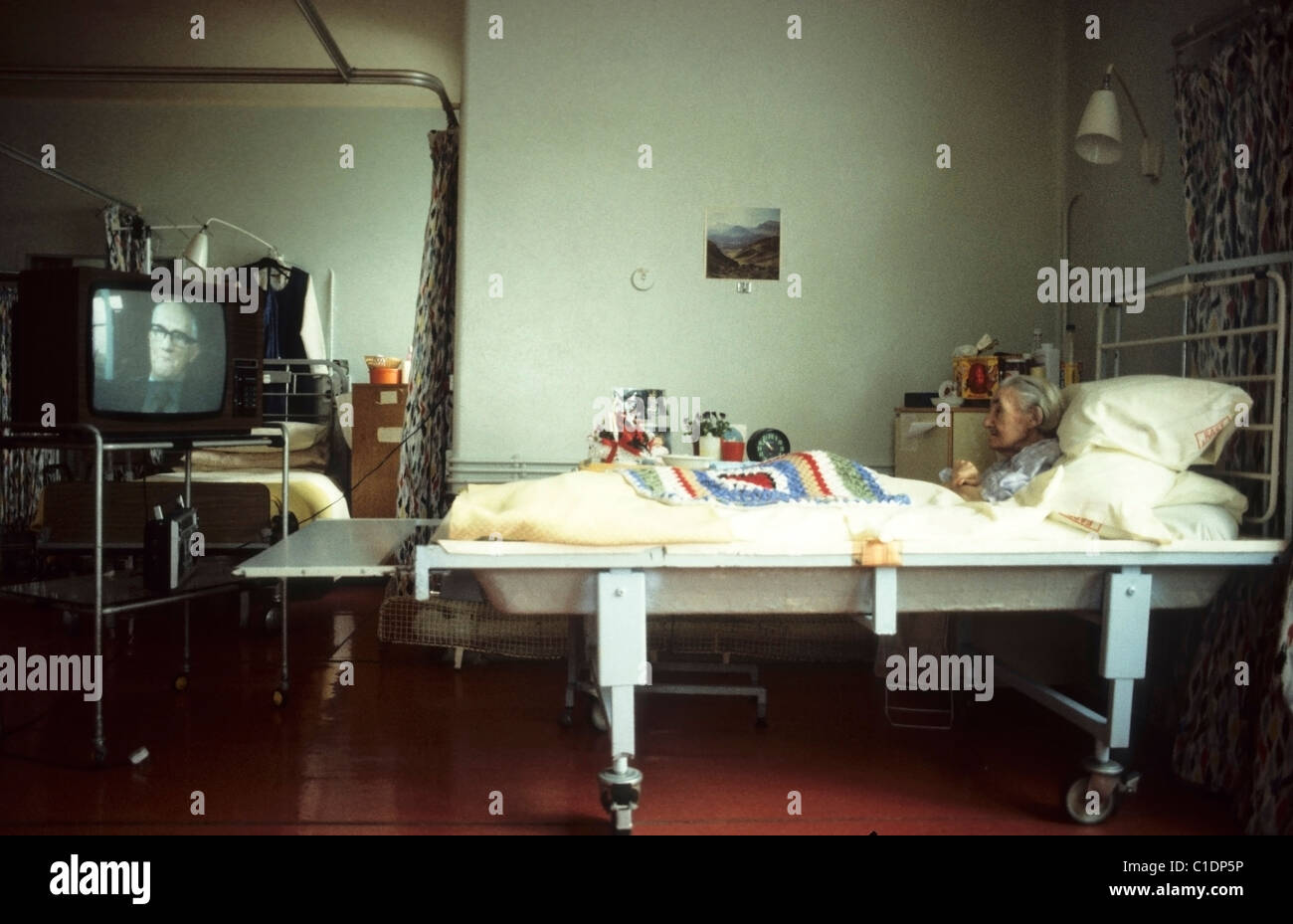 An elderly woman female patient with a crocheted shawl sitting up in