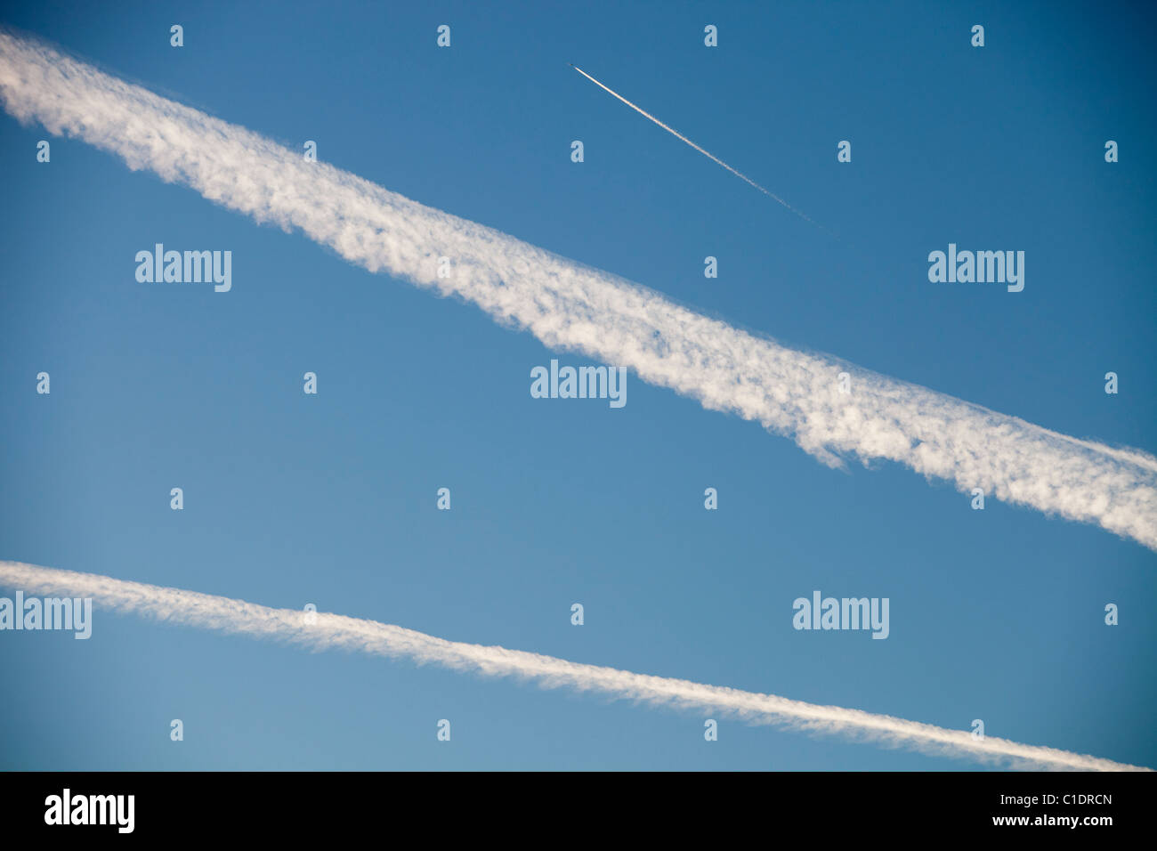A jet plane flying over the Lake District, UK, with contrails in the