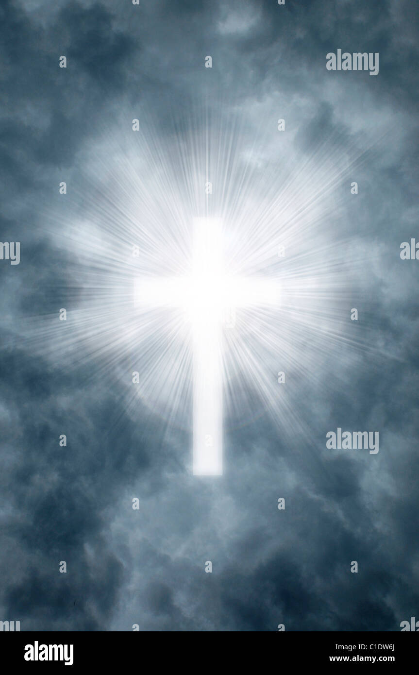 Heavenly rays shining through gray clouds in the shape of a Christian cross Stock Photo