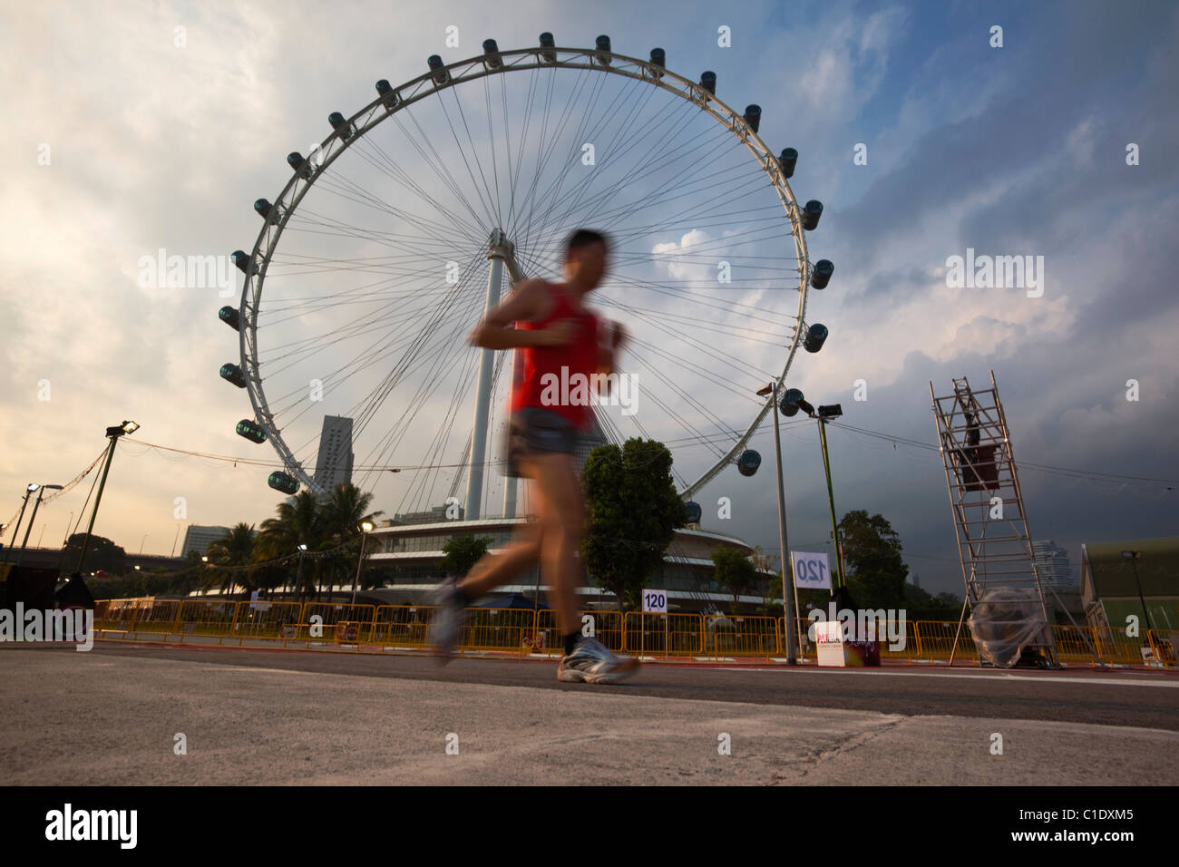 Man jogging with the Singapore Flyer in background.  Marina Bay, Singapore Stock Photo
