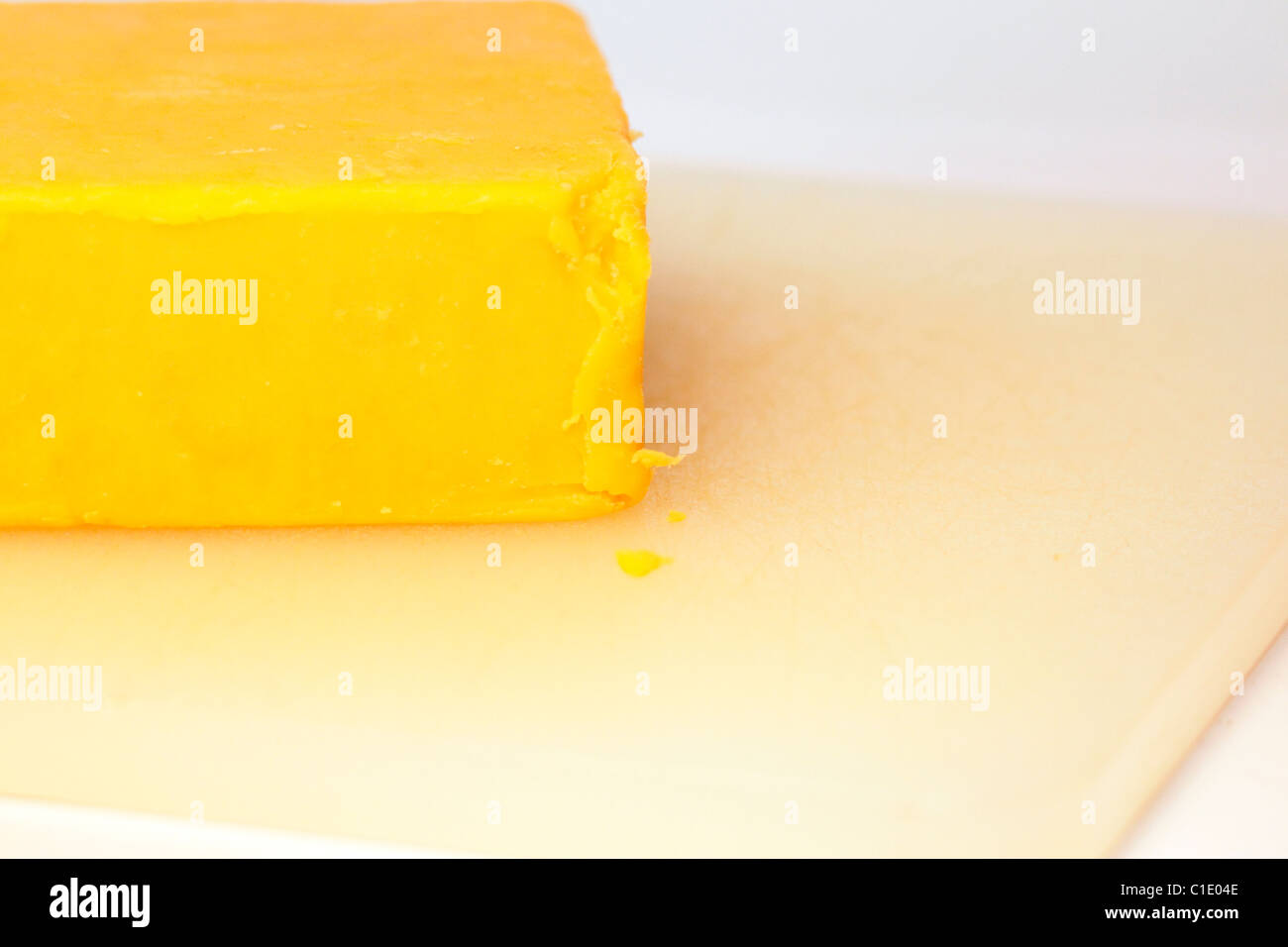 Block of  Colby Cheddar cheese on a cutting board Stock Photo