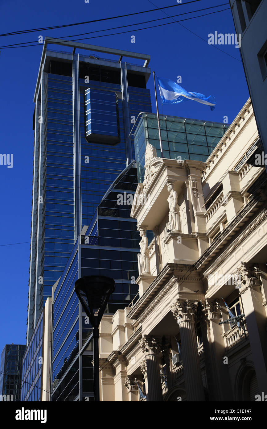 Stone building of [Central Bank of the Argentine Republic], Buenos Aires flying Argentine flag contrasted with modern skyscraper Stock Photo