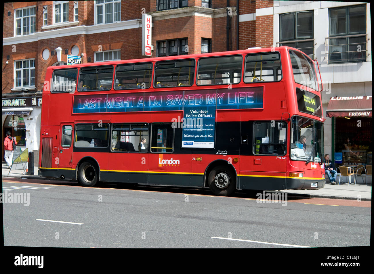 A double deck bus parked near Victoria station has an advert for volunteer police officers on the side Stock Photo