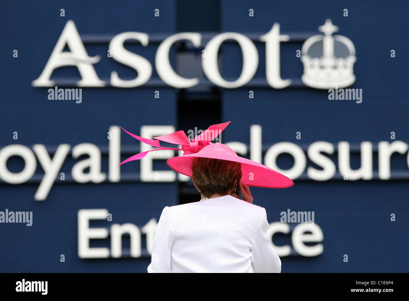 Woman in hat standing in front of the Royal Enclosure of the horse race track, Ascot, United Kingdom Stock Photo
