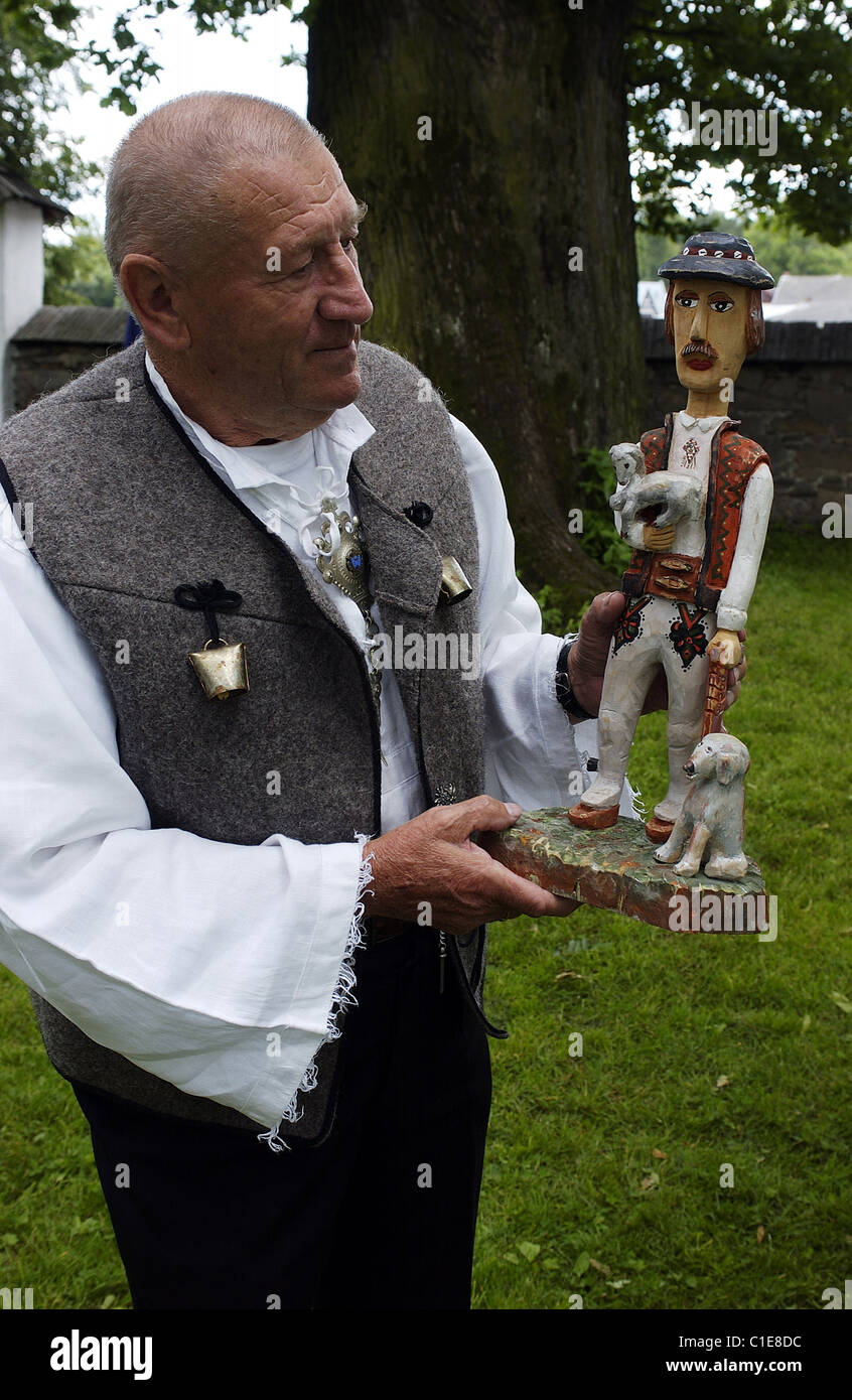 Poland Lesser Poland Carpathian Mountains Eugeniusz Bogucki wood-carver in traditional costume of the area presenting one of Stock Photo