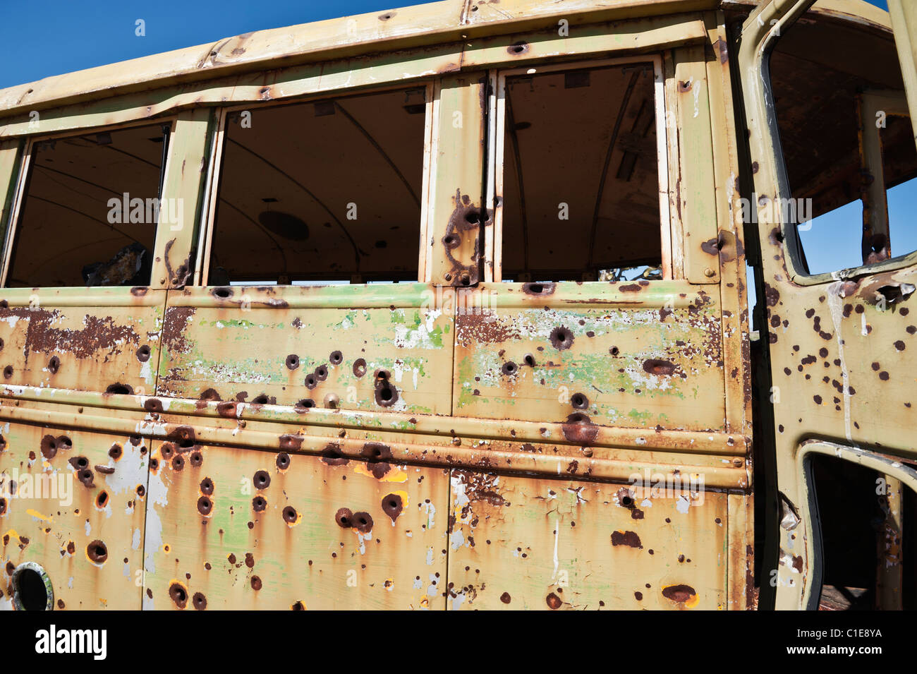 Abandoned bus with rusty bullet holes, Mojave desert, California Stock Photo