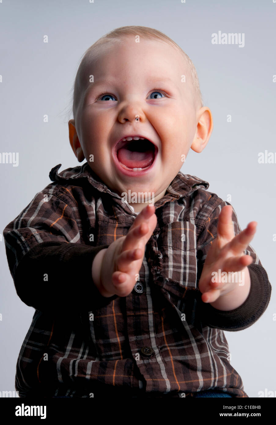 Nine month old baby boy smiling, laughing, clapping hands very happy
