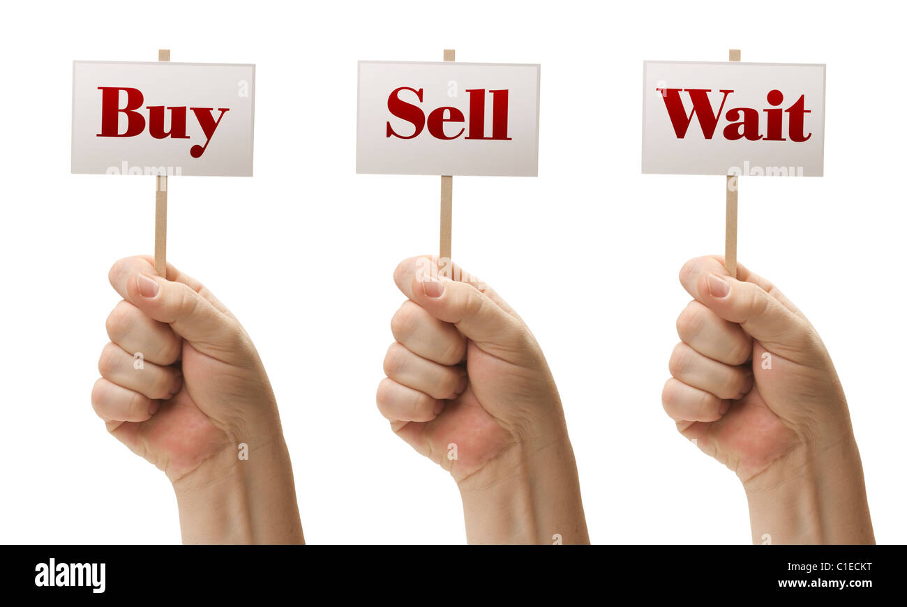 Three Signs In Male Fists Saying Buy, Sell and Wait Isolated on a White Background. Stock Photo