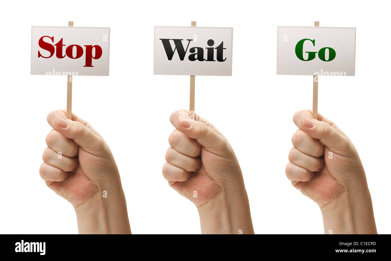 Three Signs In Male Fists Saying Stop, Wait and Go Isolated on a White Background. Stock Photo