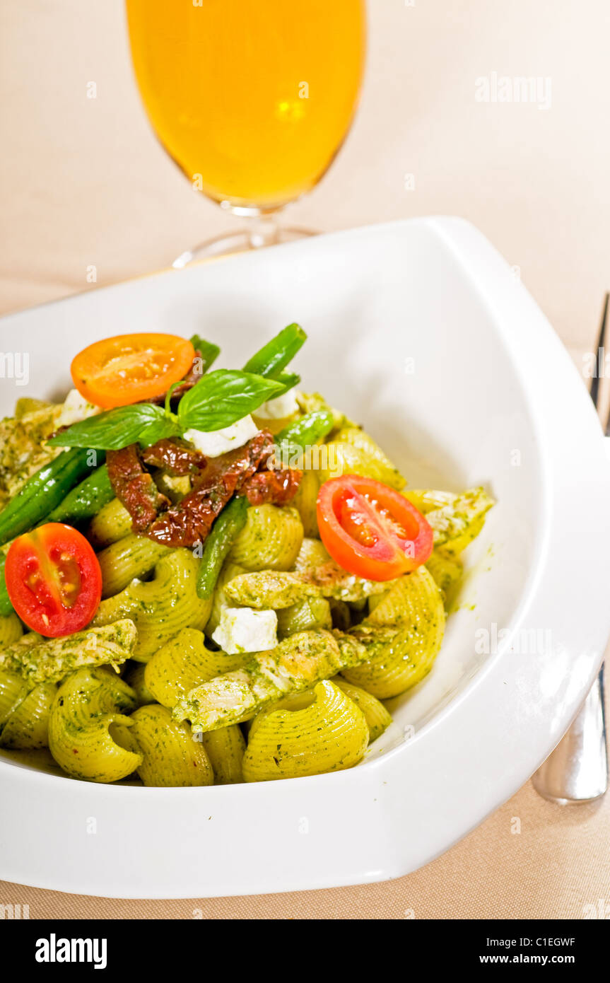 fresh lumaconi pasta and pesto sauce with vegetables and sundried tomatoes,tipycal italian food Stock Photo