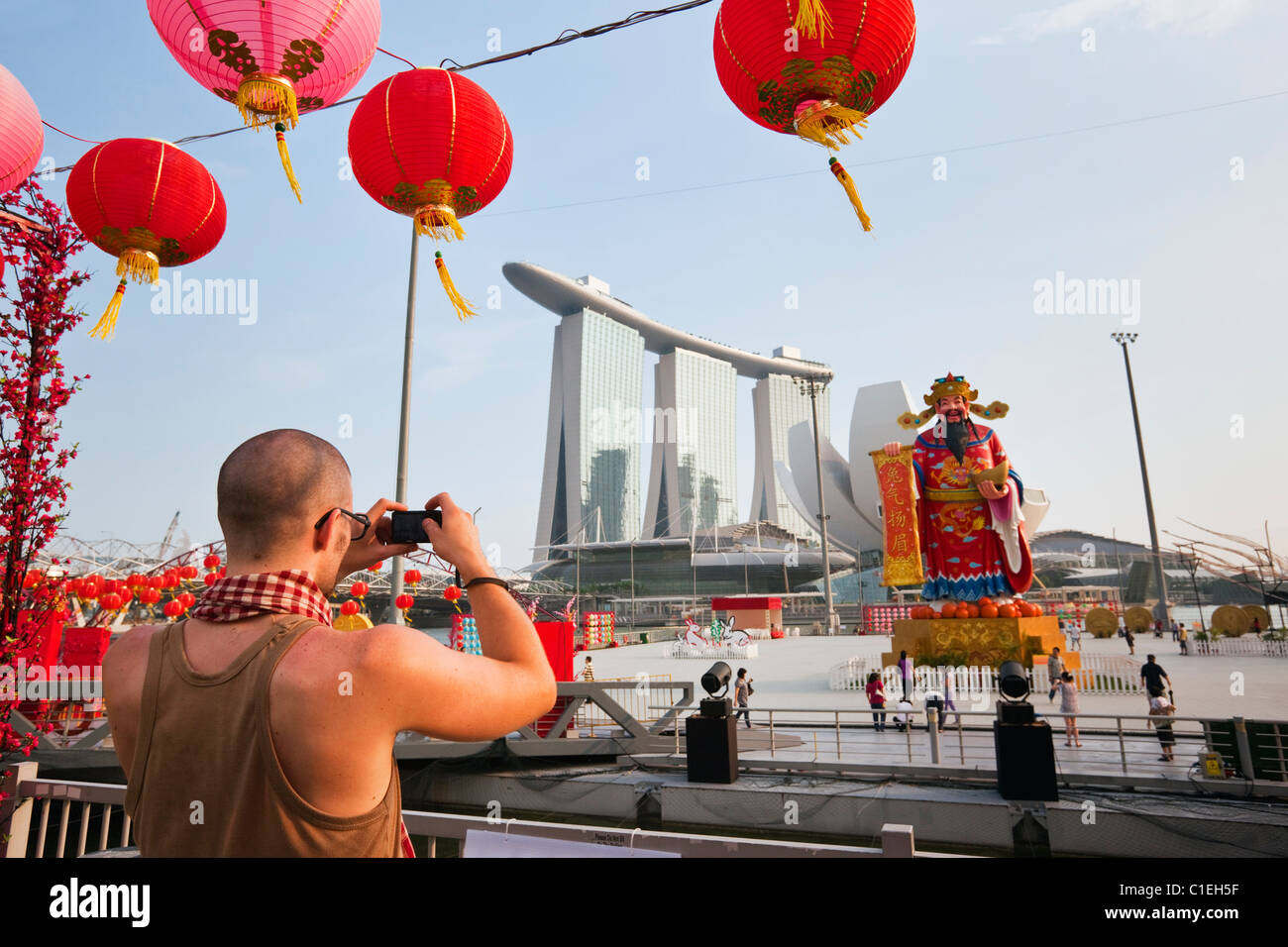 A tourist photographs River Hongbao Chinese New Year decorations and the Marina Bay Sands Hotel.  Marina Bay, Singapore Stock Photo