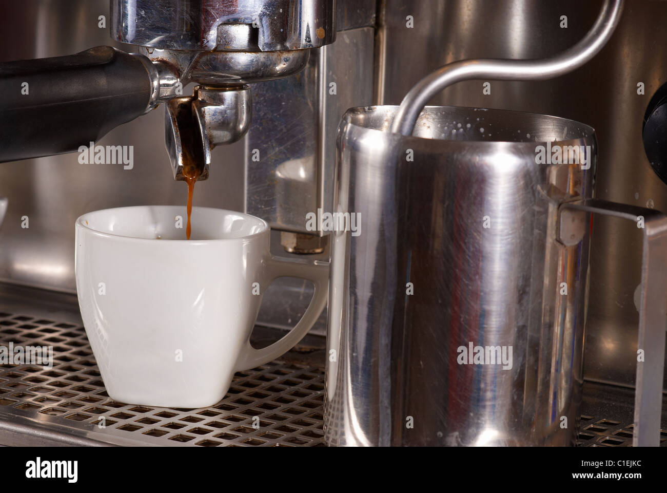 Industrial espresso machine steaming milk and filtering coffee Stock