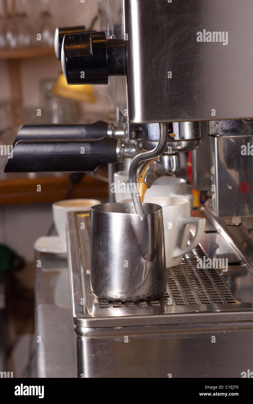 Industrial espresso machine steaming milk and filtering coffee Stock