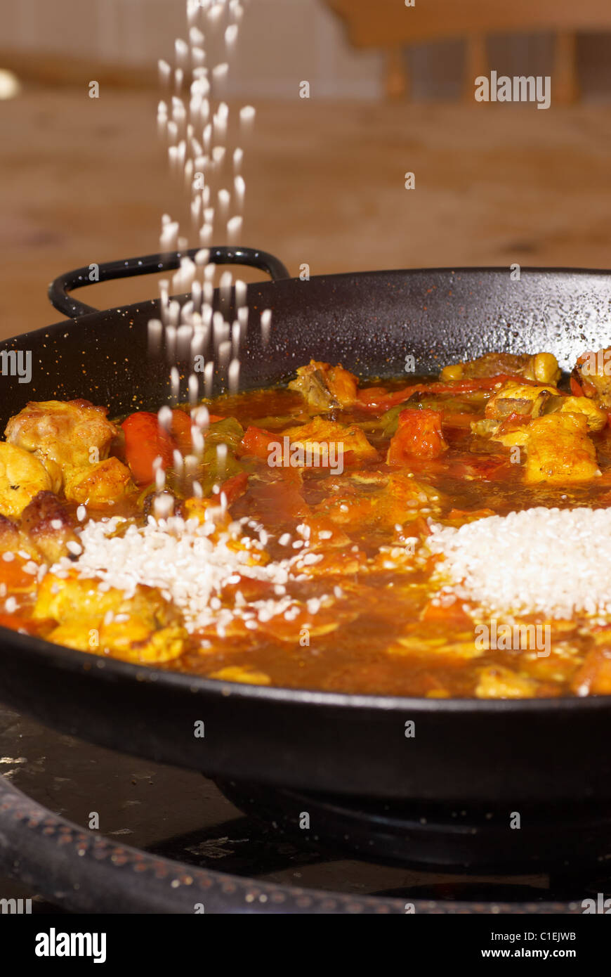 Paella Rice Adding Pouring rice into a paella pan, traditional cooking Stock Photo - Alamy