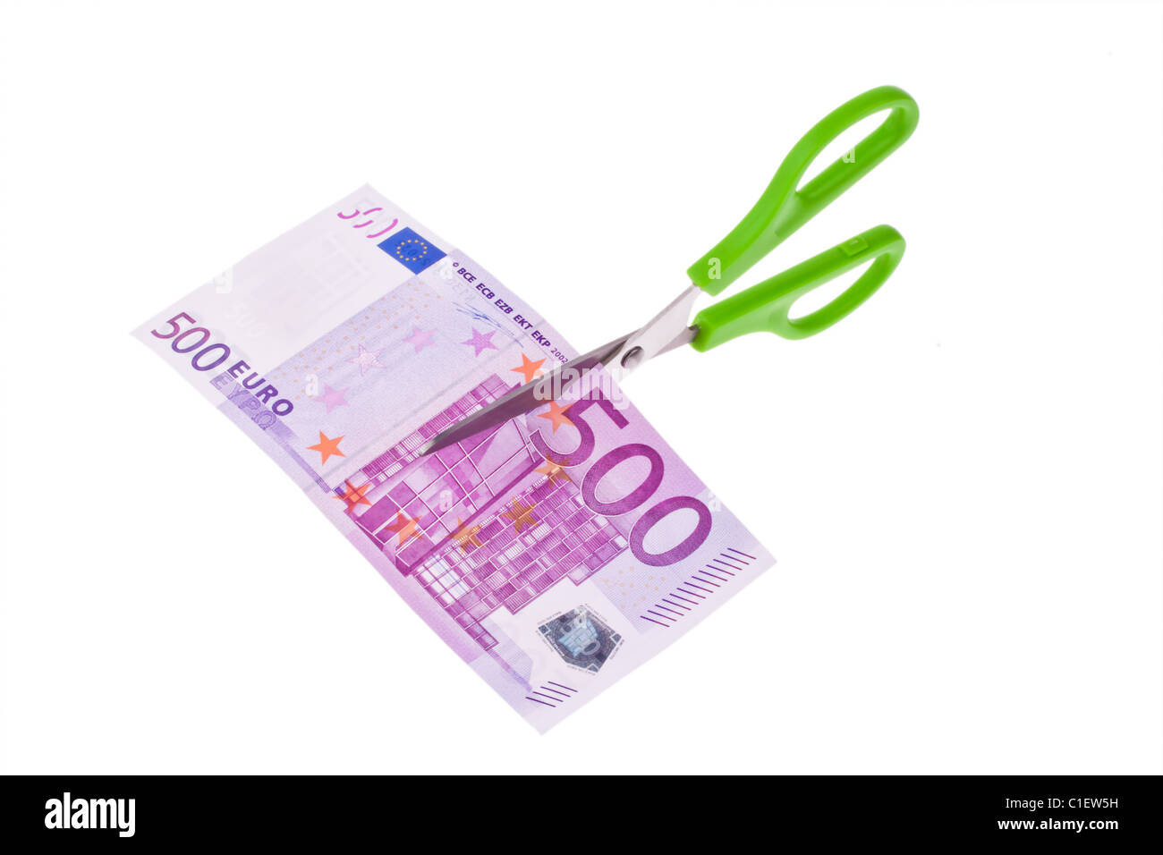 From an Euro banknote a piece is cut with scissors. Symbol taxes and fees. Stock Photo