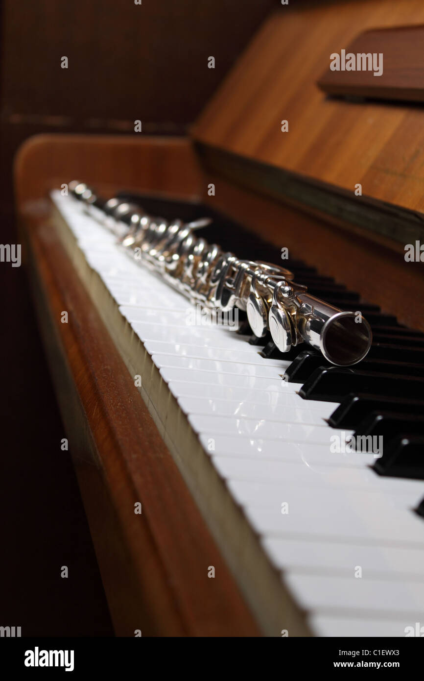Flute lying on an old piano keyboard Stock Photo Alamy