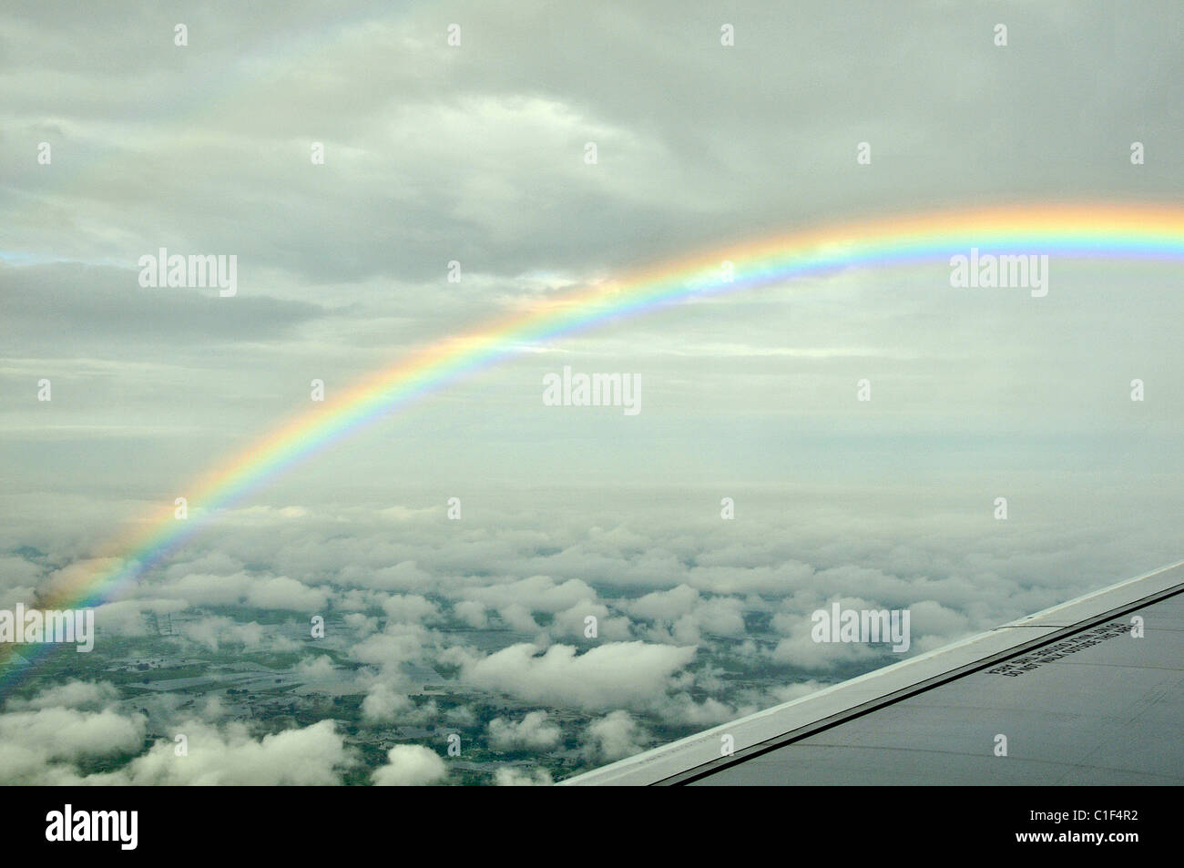 wing of airplane and rainbow Stock Photo