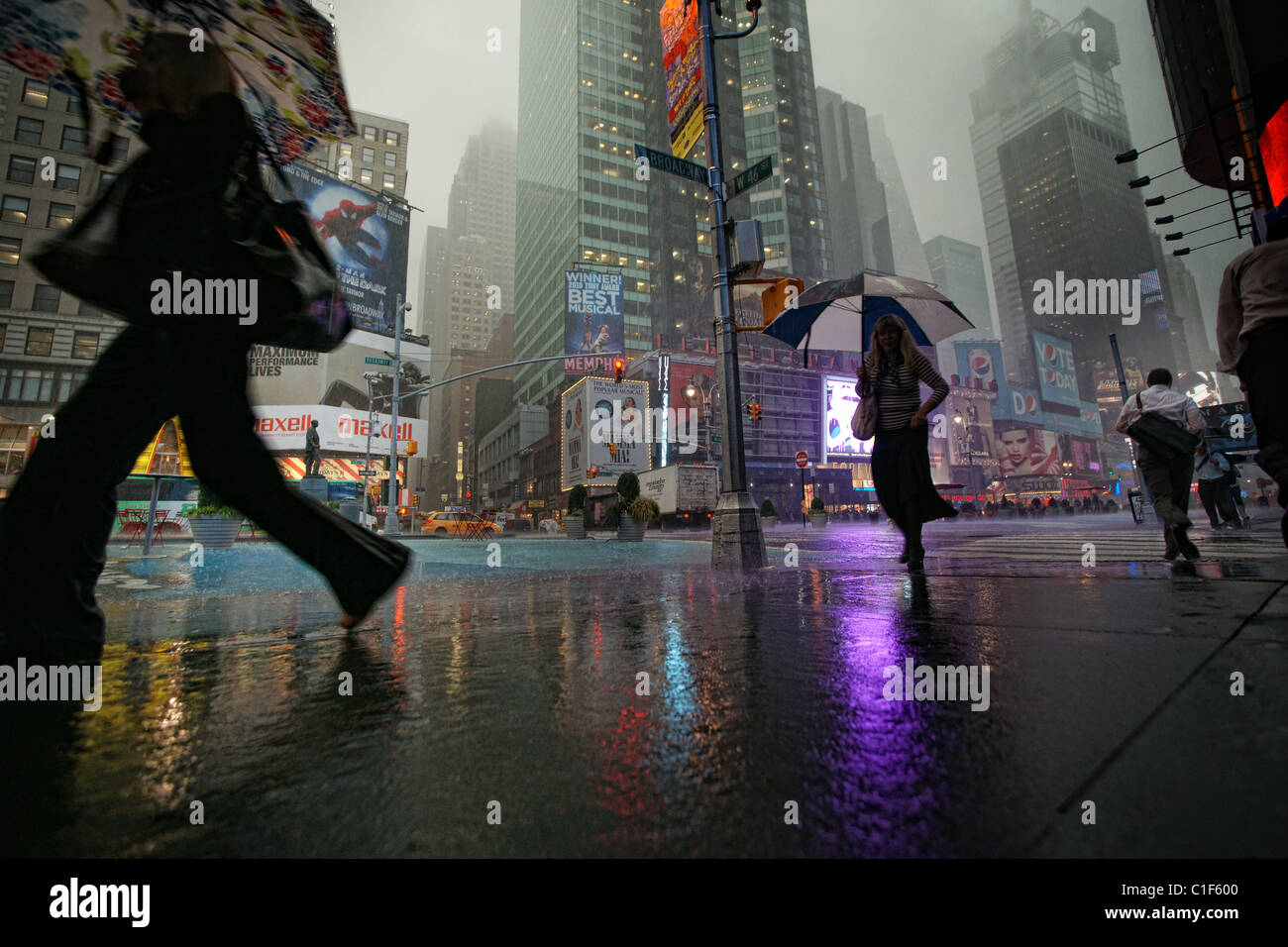 People with umbrellas on Time Square, New York, in the rain Stock Photo
