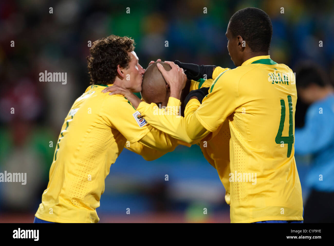 Elano of Brazil (l) kisses the head of Maicon (c) after Maicon scored a goal against North Korea during a 2010 World Cup match. Stock Photo