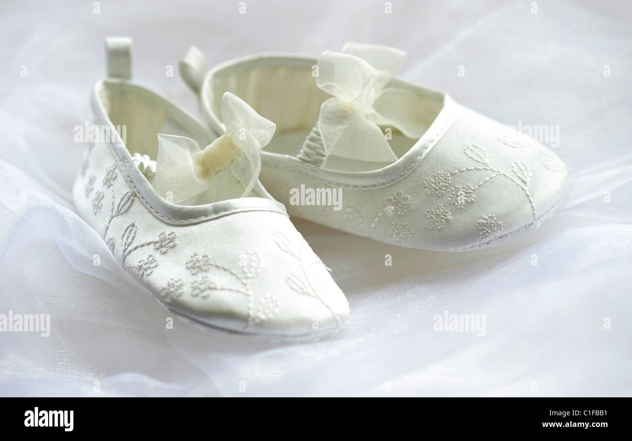 ivory bridesmaid flower girl shoes on white tulle with tulle bows and embroidered material Stock Photo