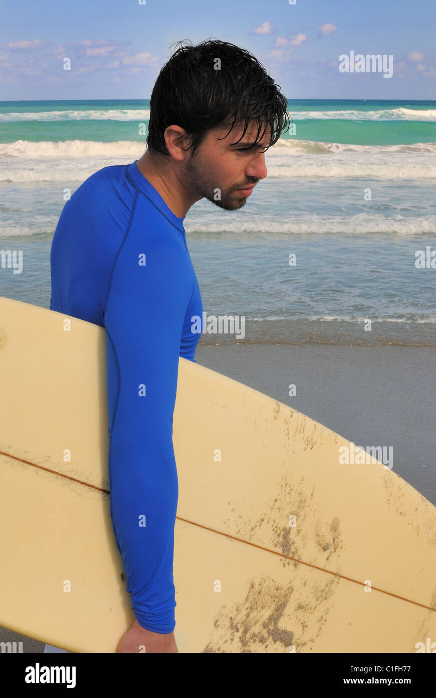 Surfer on the beach with his board. Stock Photo