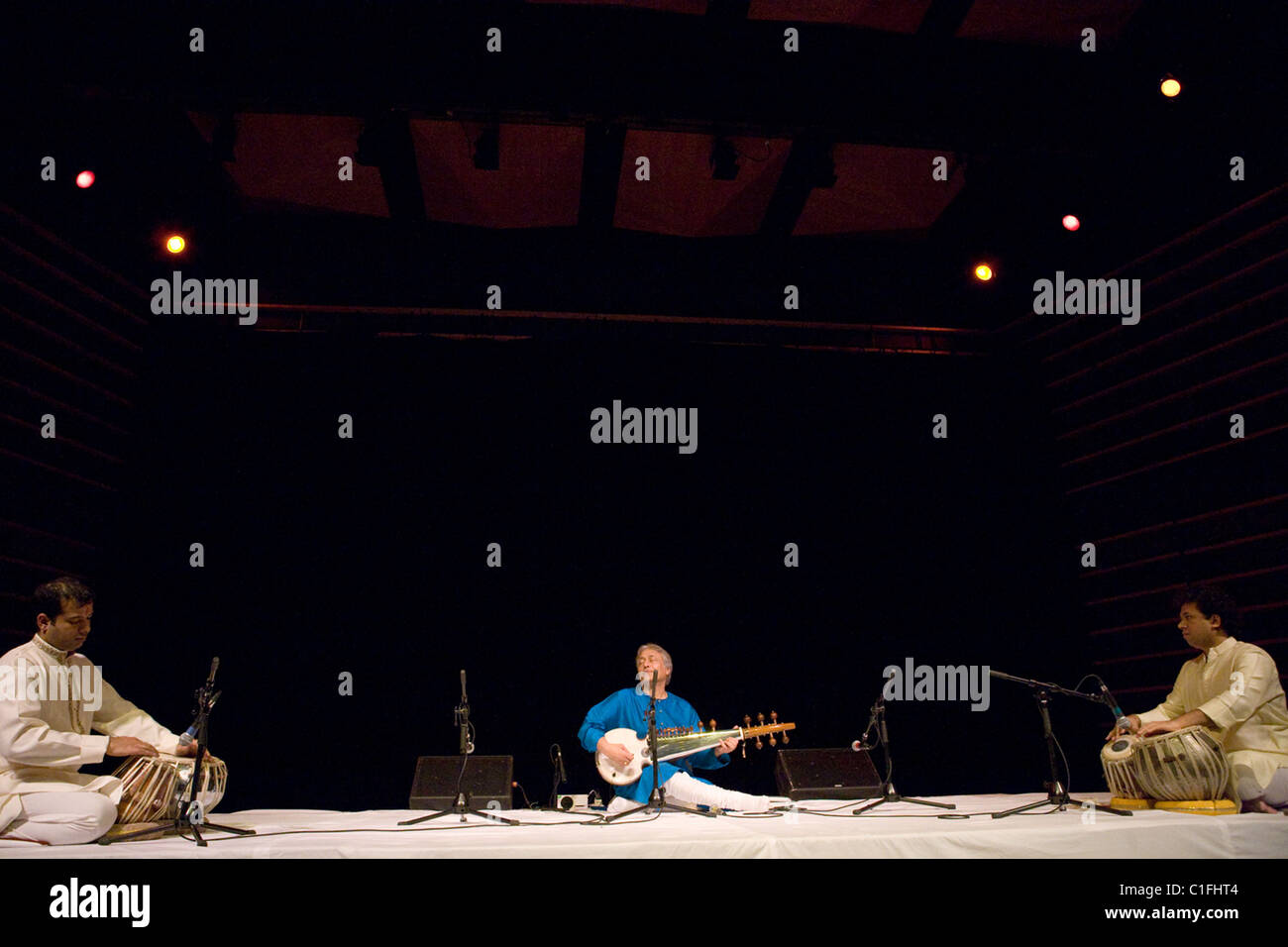 Classical Indian musicians perform onstage including famous sarod